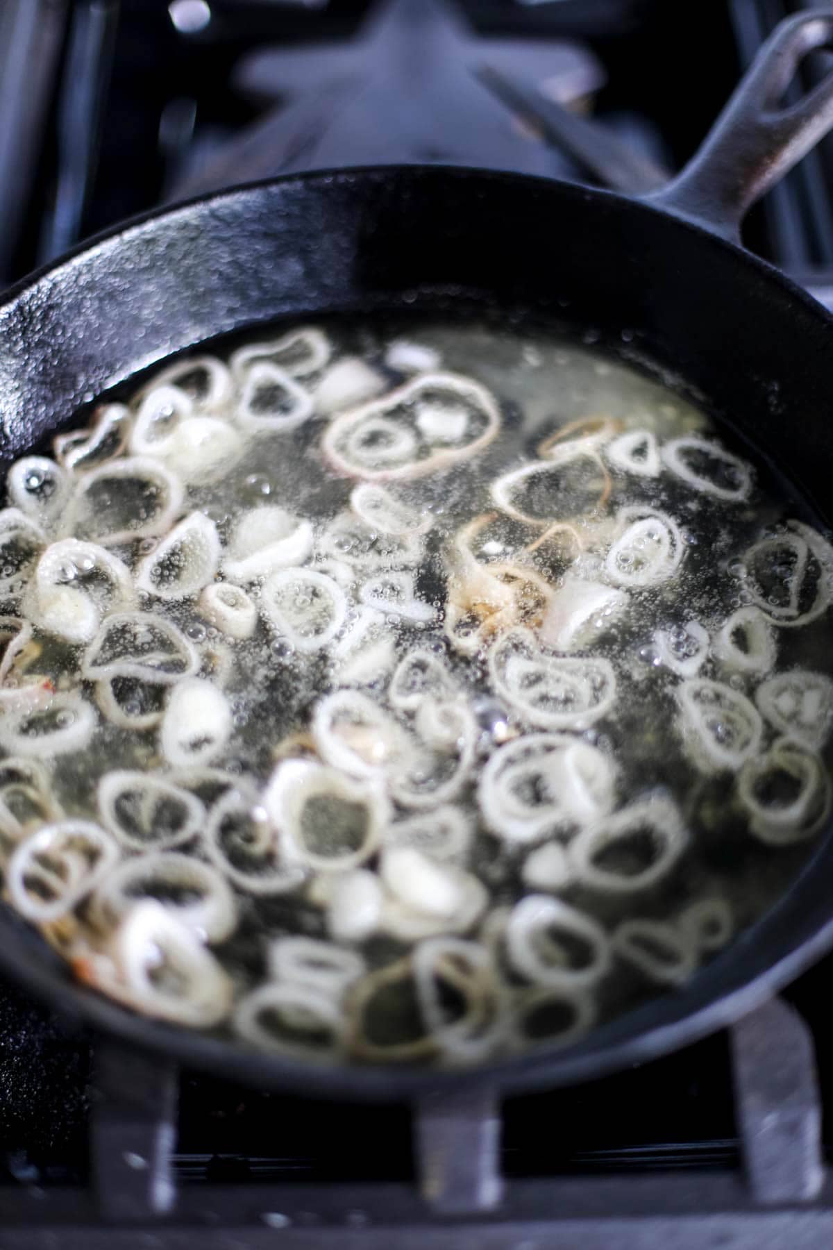Frying shallots in a cast iron pan.