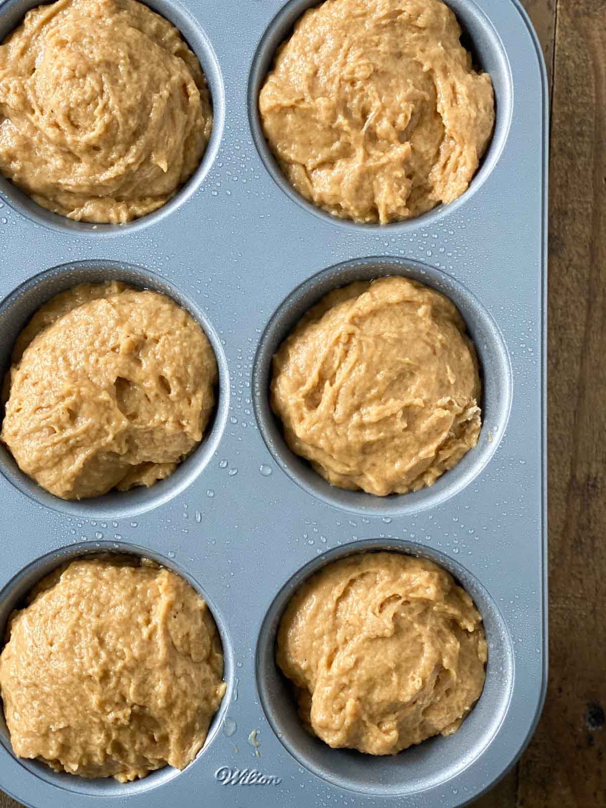 Pumpkin muffin batter in a pan.