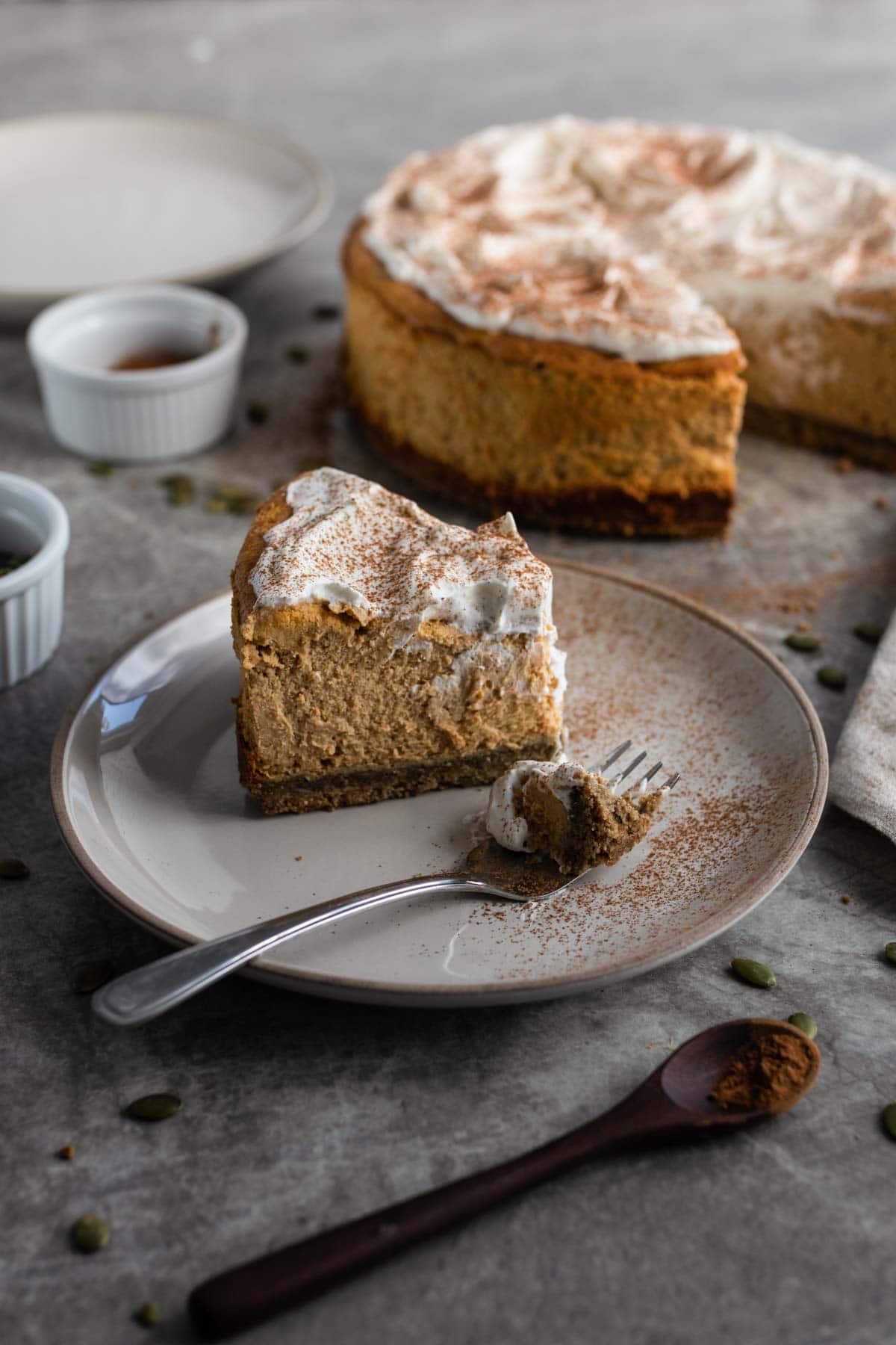 A slice of pumpkin cheesecake with whipped cream.