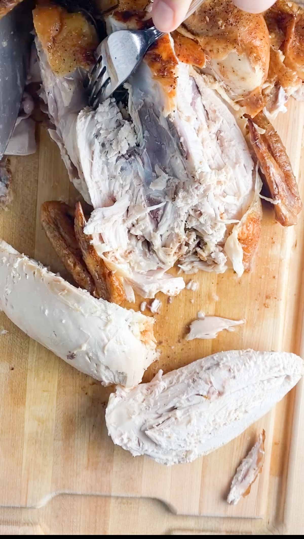 Cutting off chicken legs from a whole chicken.