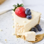 A white chocolate cheesecake slice with berries on top.