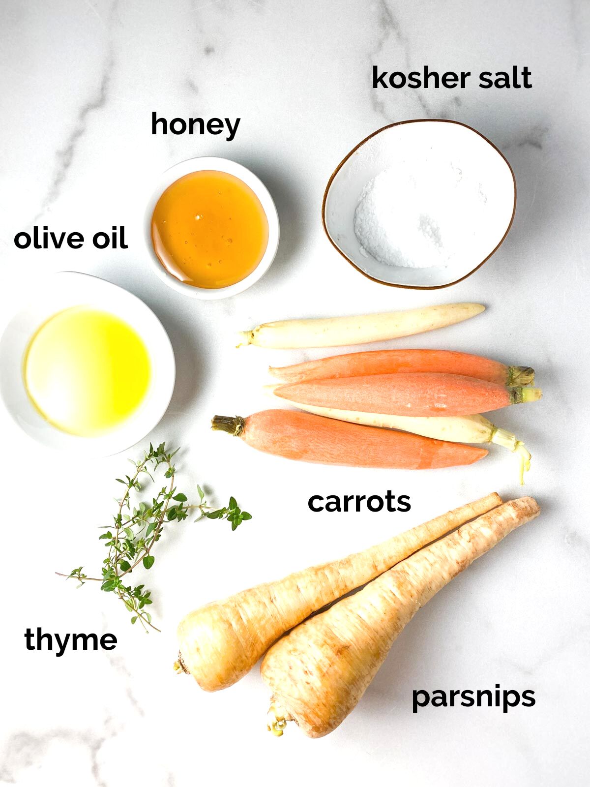 Carrots, parsnips, and honey on a table.