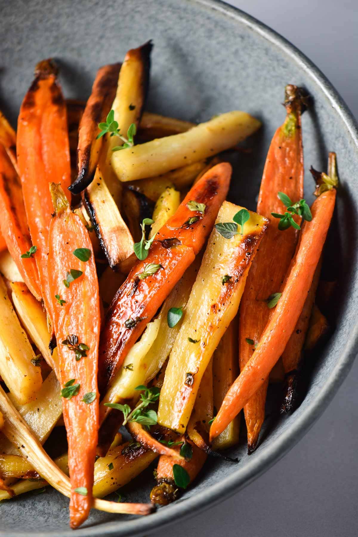 Honey roasted carrots and parsnips topped with thyme leaves.