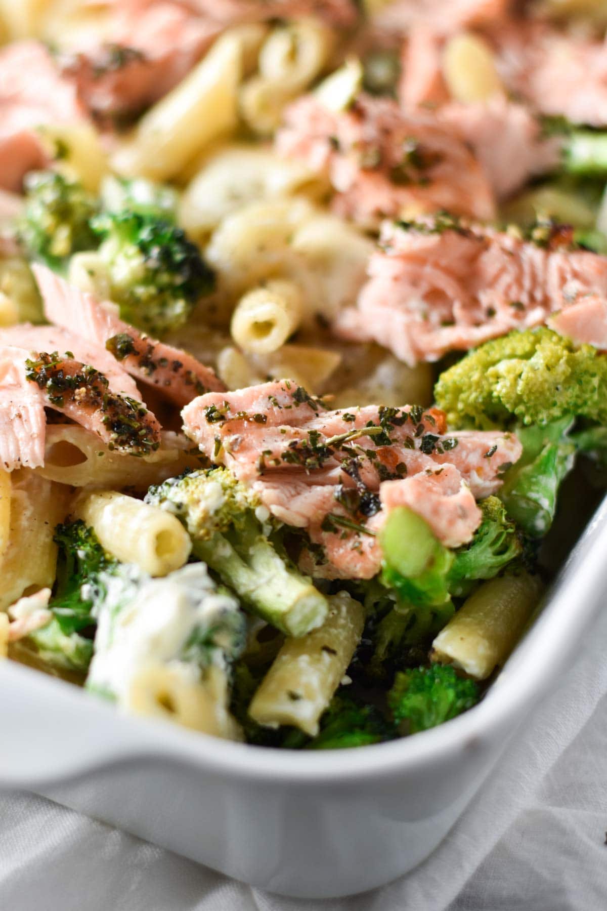 Salmon broccoli pasta in a white roasting pan.