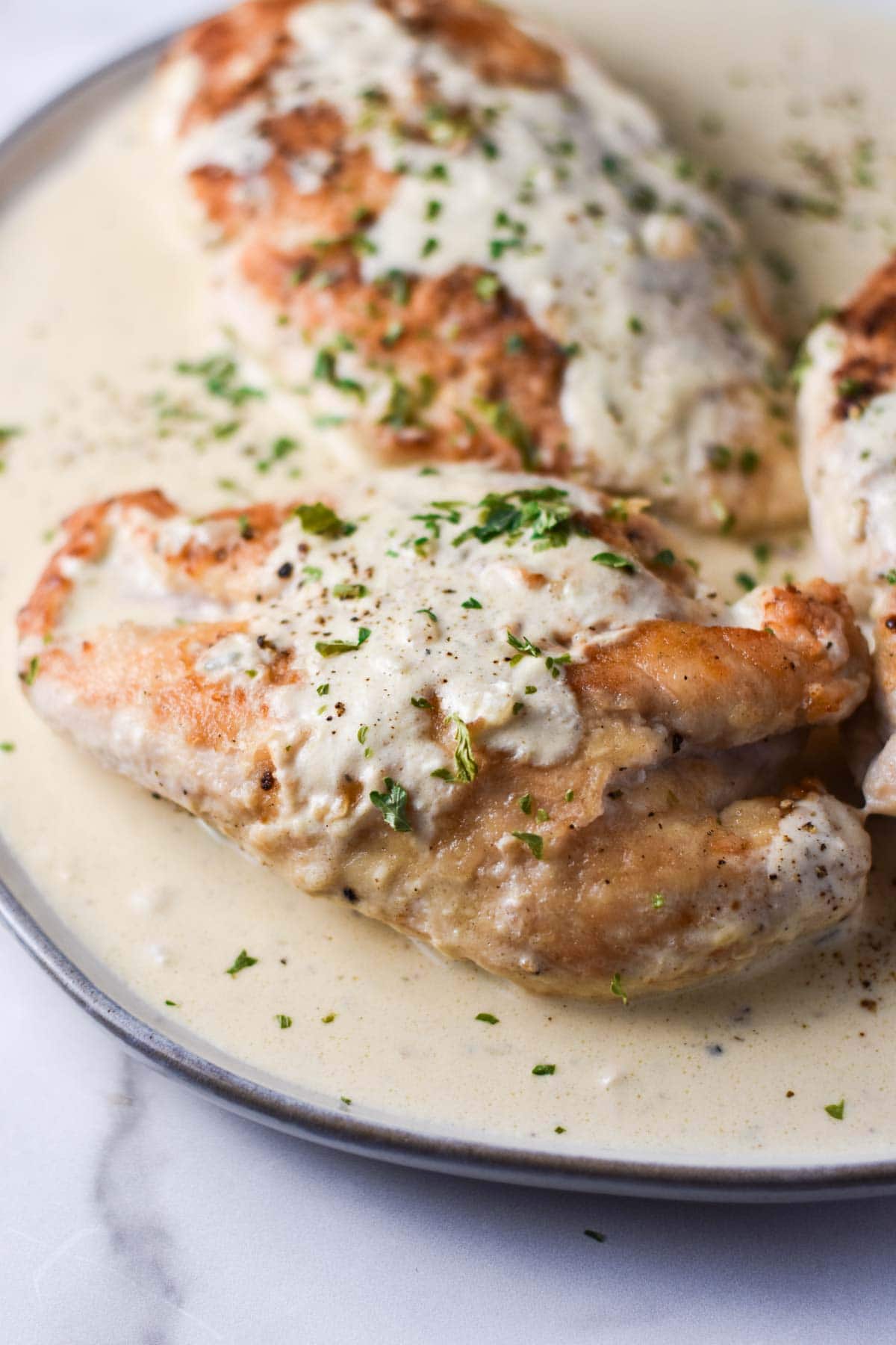 Topping seared chicken with cream sauce.