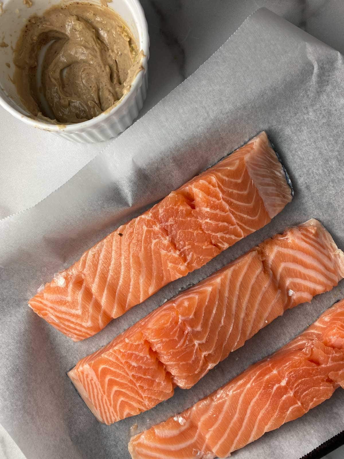 Salmon next to dijon mustard and spices.