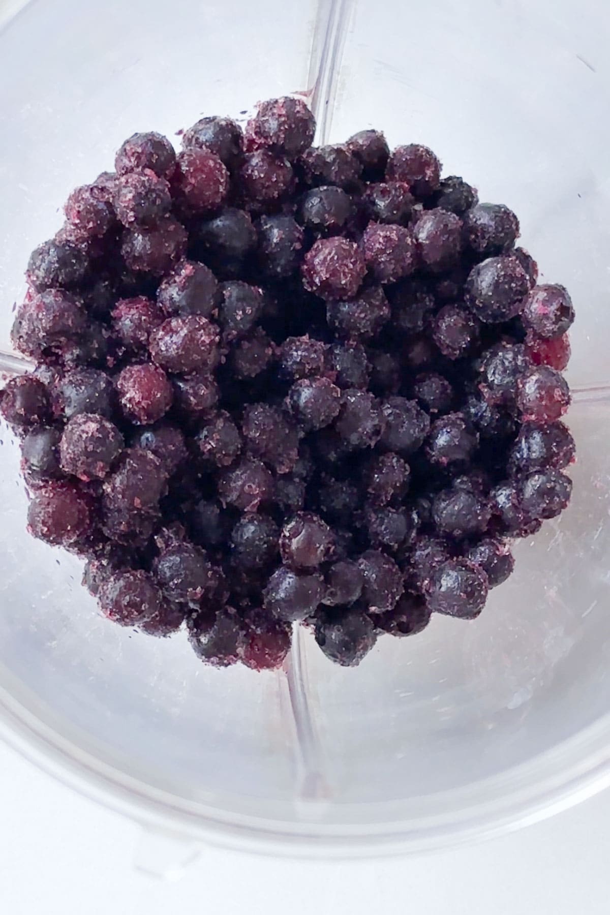 Wild frozen blueberries in a blender before blending.