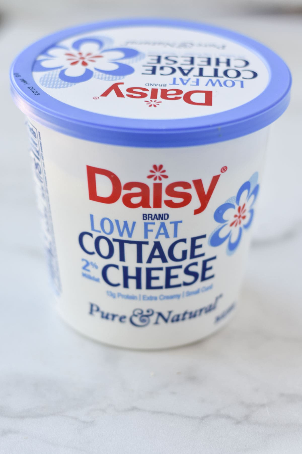 Low fat daisy cottage cheese on a marble table.
