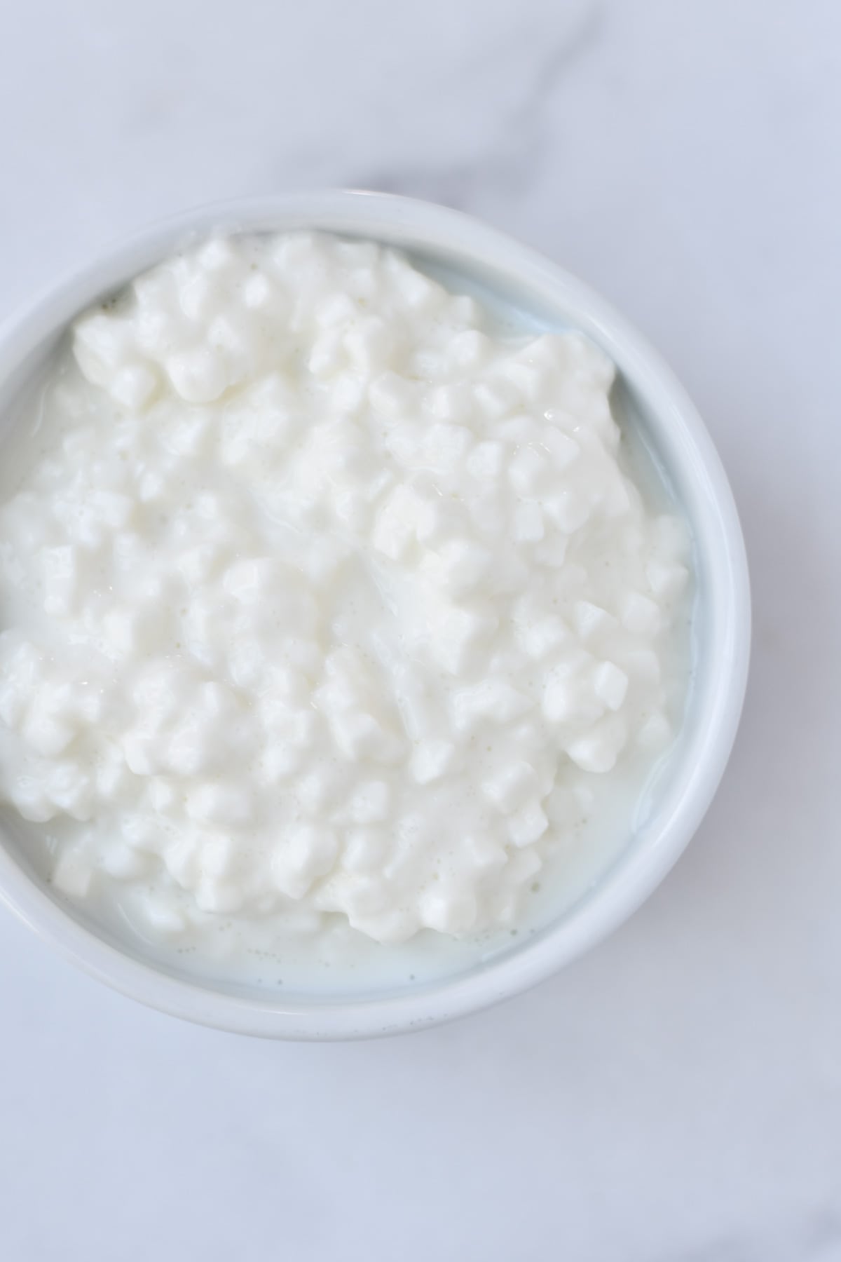 A white bowl of cottage cheese.