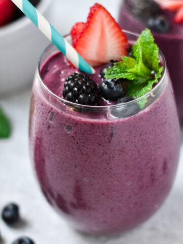 A berry smoothie with mixed berries on top.