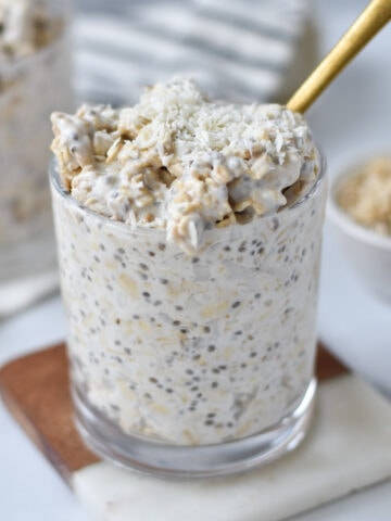 A gold spoon in coconut overnight oats.