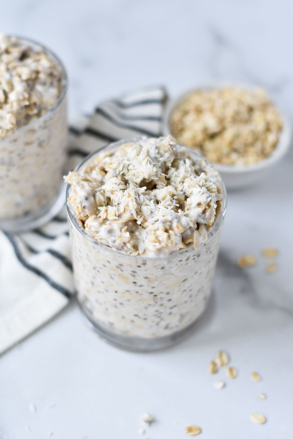 Two cups of overnight oats topped with coconut.