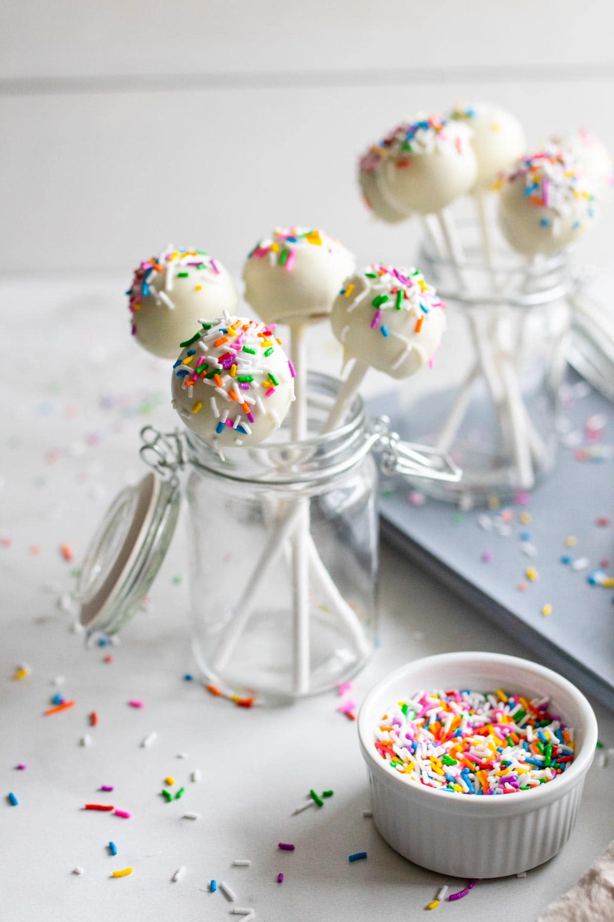 White chocolate cake pops in a glass container.