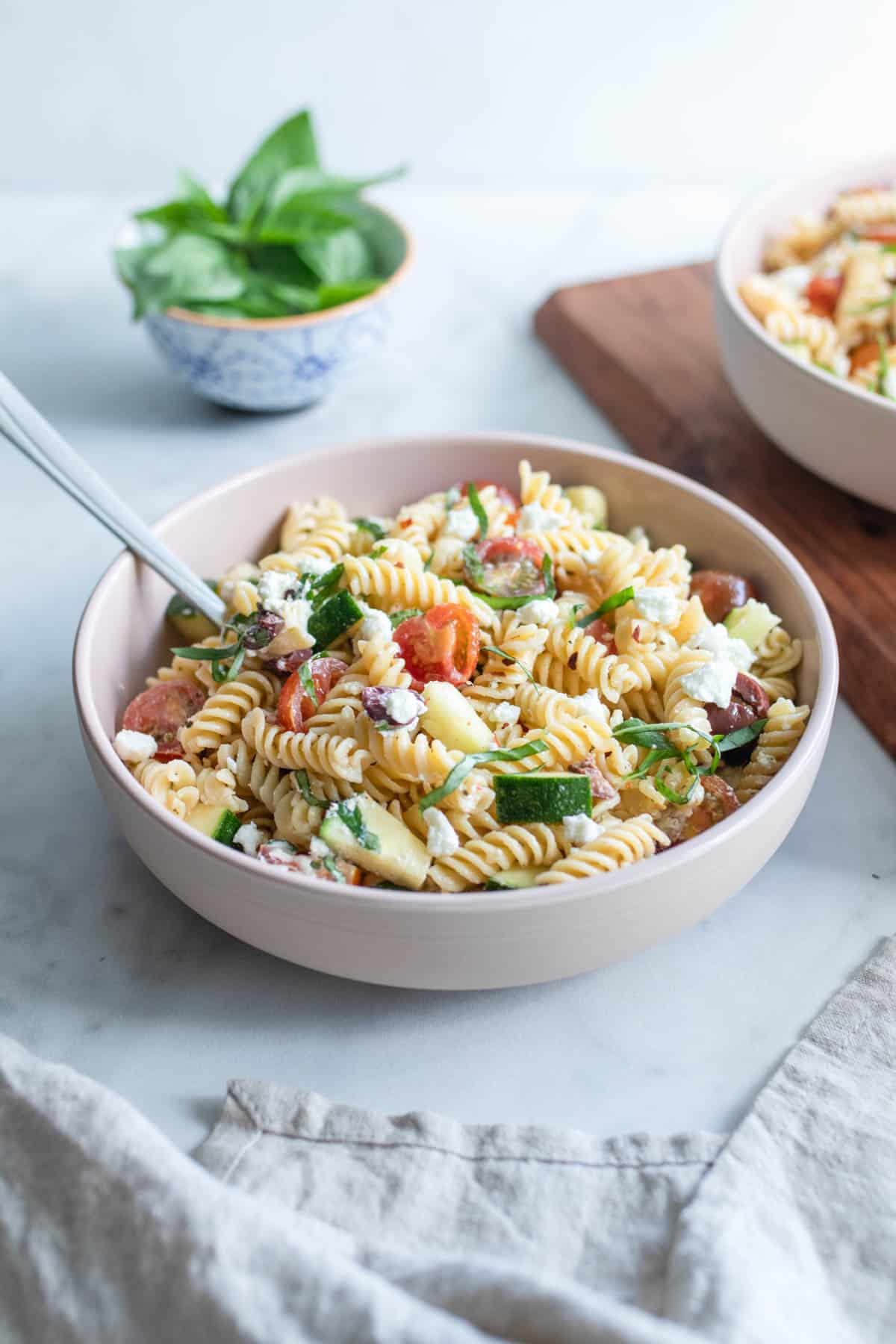 A bowl of chickpea pasta salad with a fork.