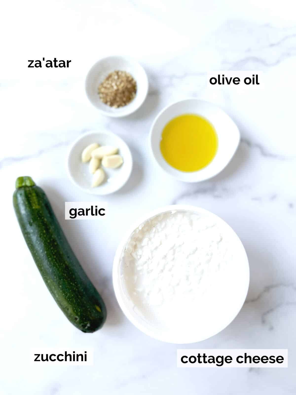 Ingredients for cottage cheese dip on a white marble background.