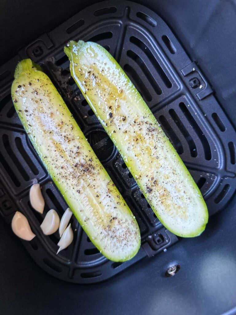 Zucchini and garlic in an air fryer before cooking.