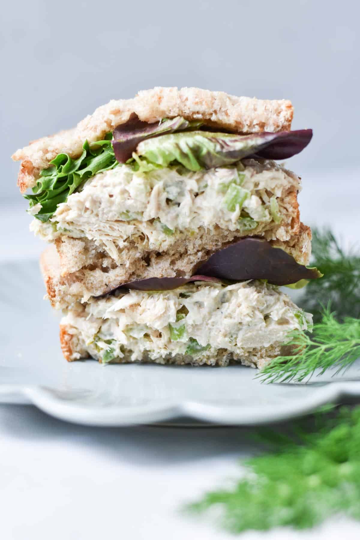 Tuna salad sandwiches stacked on top of each other.