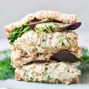 A stacked tuna salad sandwich with lettuce.