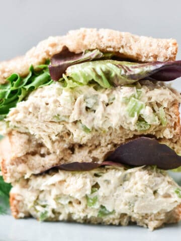 A stacked tuna salad sandwich with lettuce.