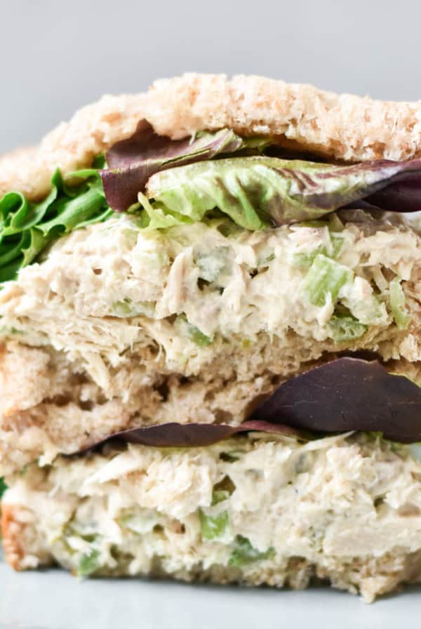 A stacked tuna salad sandwich with lettuce.