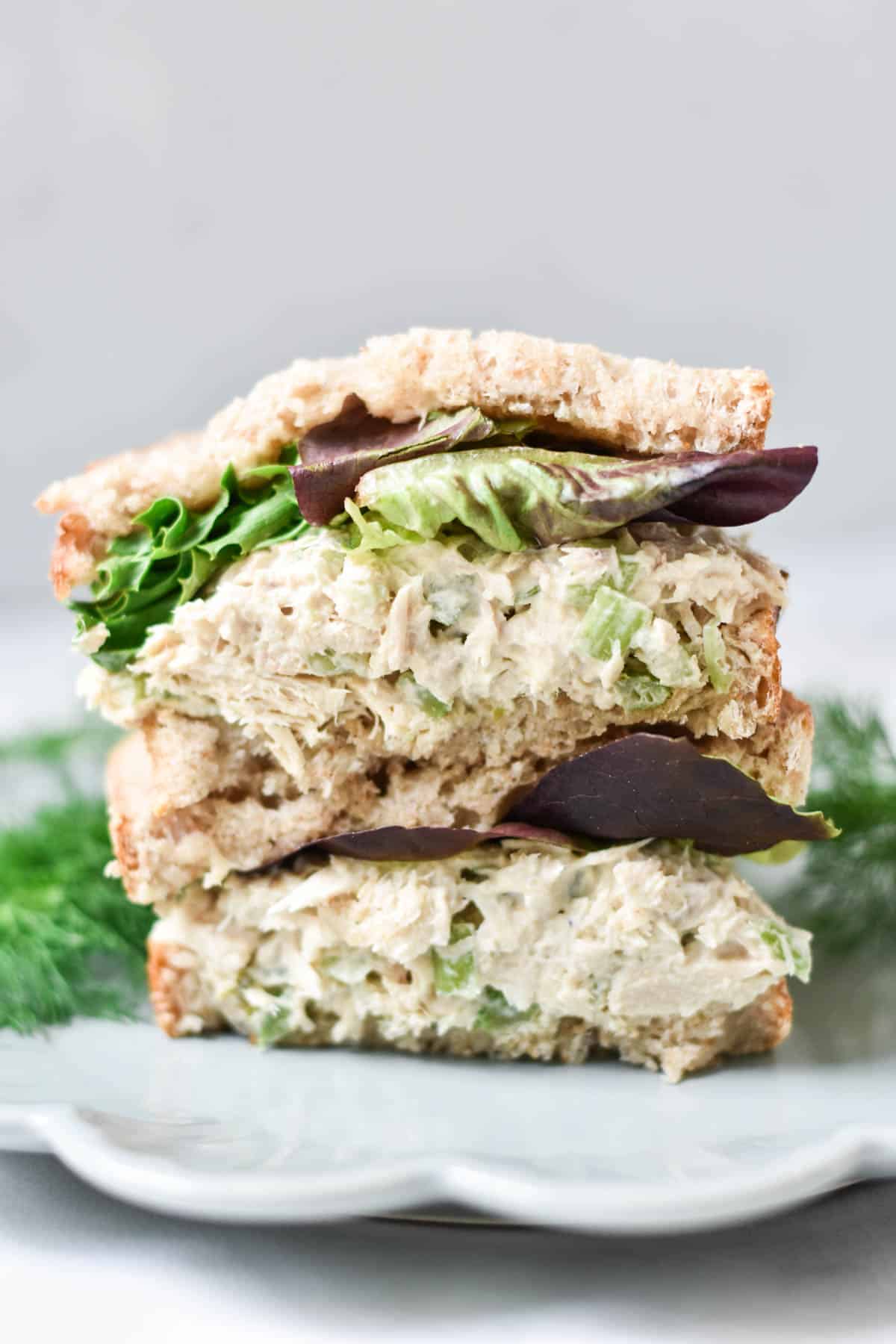 Tuna salad sandwiches stacked on each other.