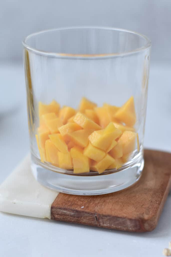 A jar filled with fresh cut mangoes.
