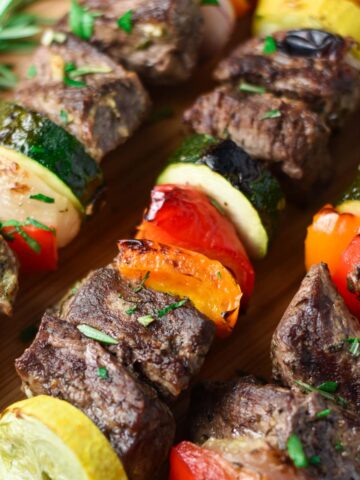 Beef kabobs with red pepper, zucchini, summer squash, and rosemary.