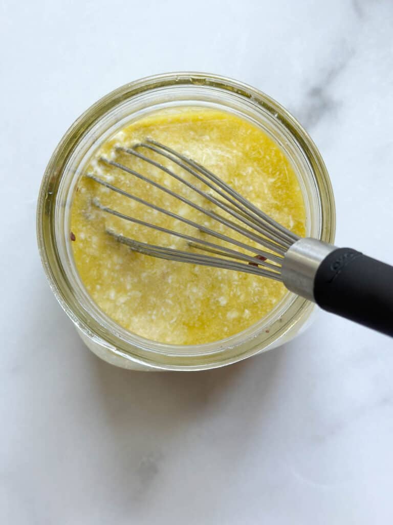 Whisking the dressing in a mason jar.