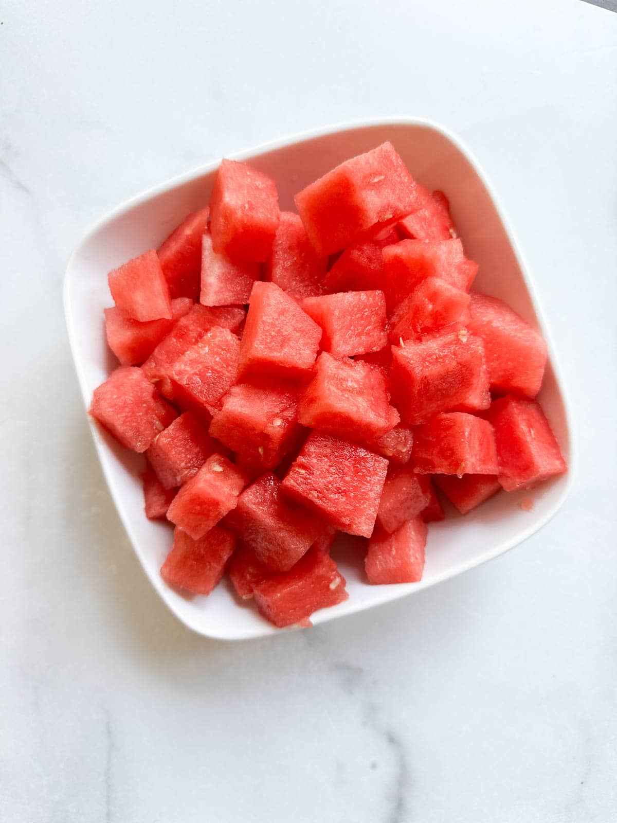 A white bowl with bright, cubed watermelon.