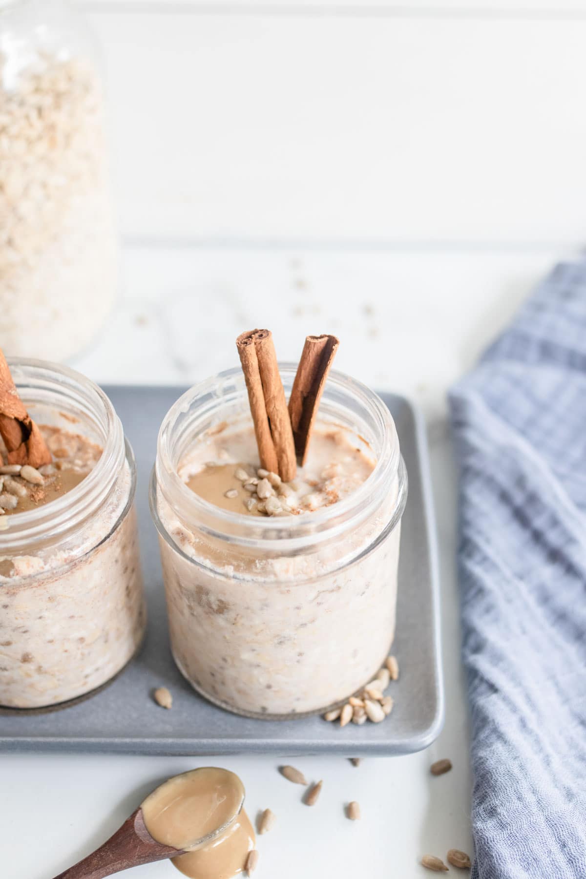 A jar of overnight oats on a baking sheet with a blue towel.