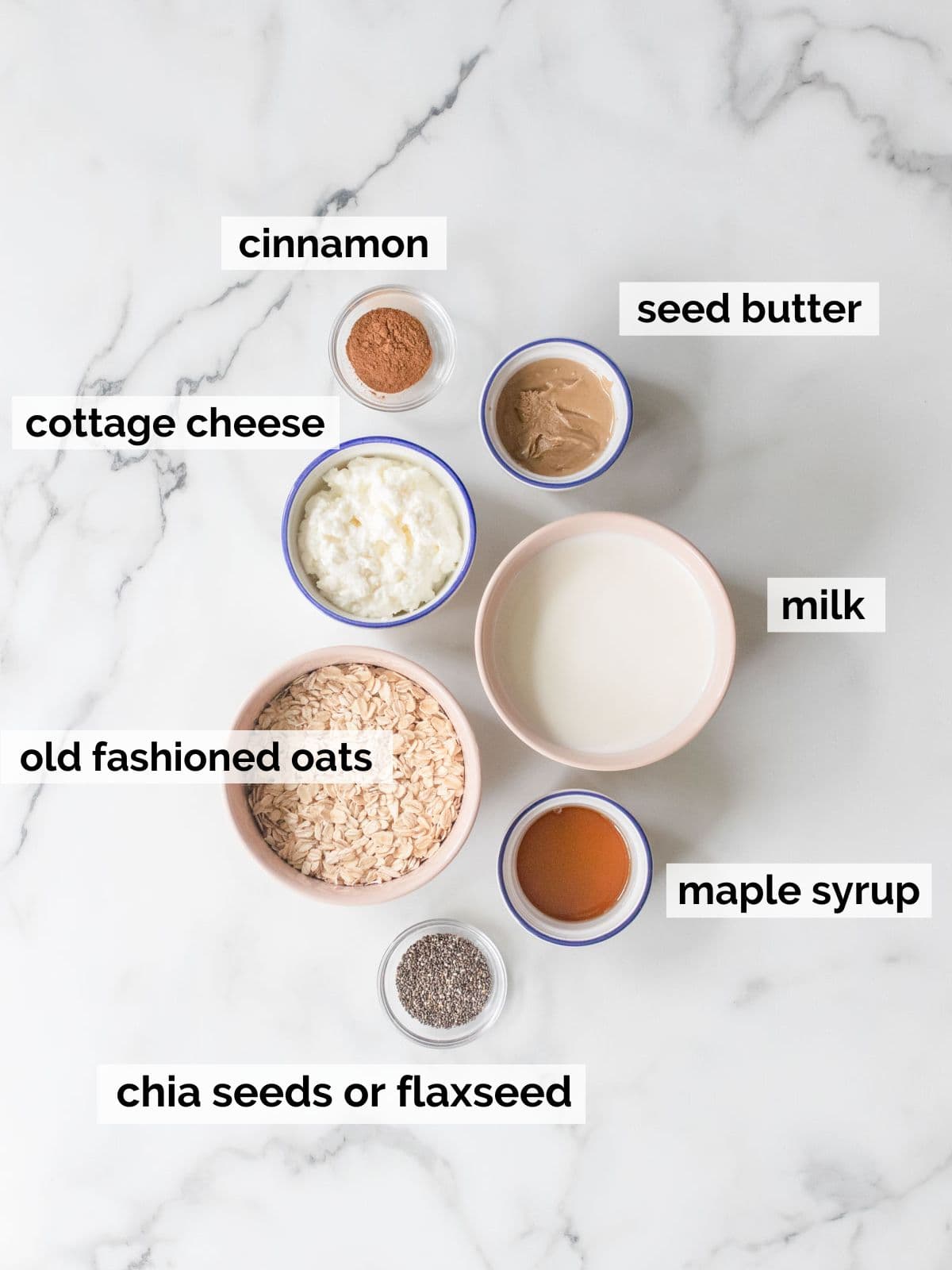 Ingredients for cinnamon overnight oats on a marble background.