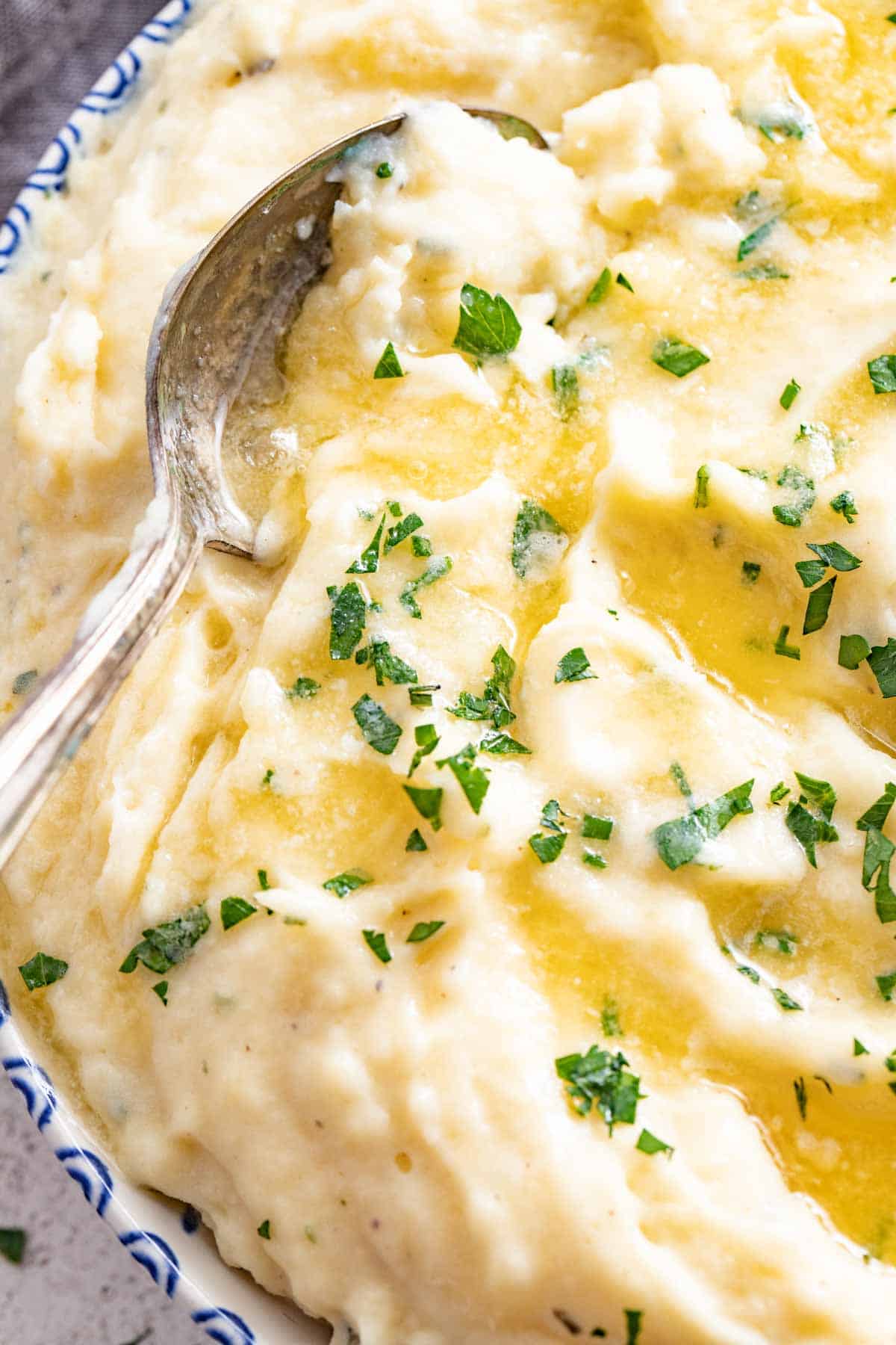 A spoon dipping into mashed potatoes.