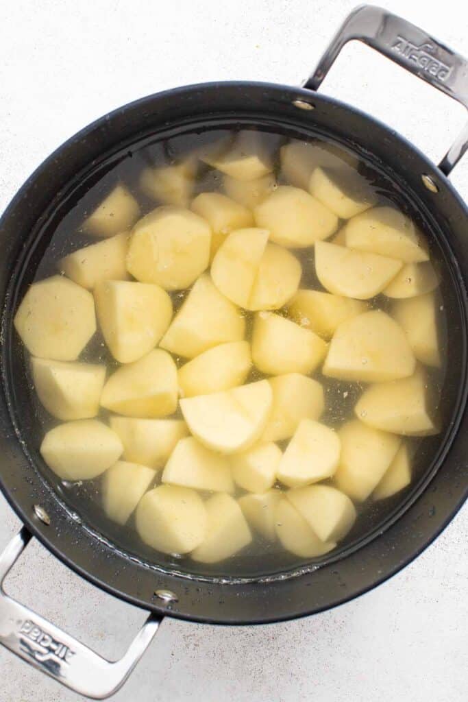 A pot of water with chopped potatoes.