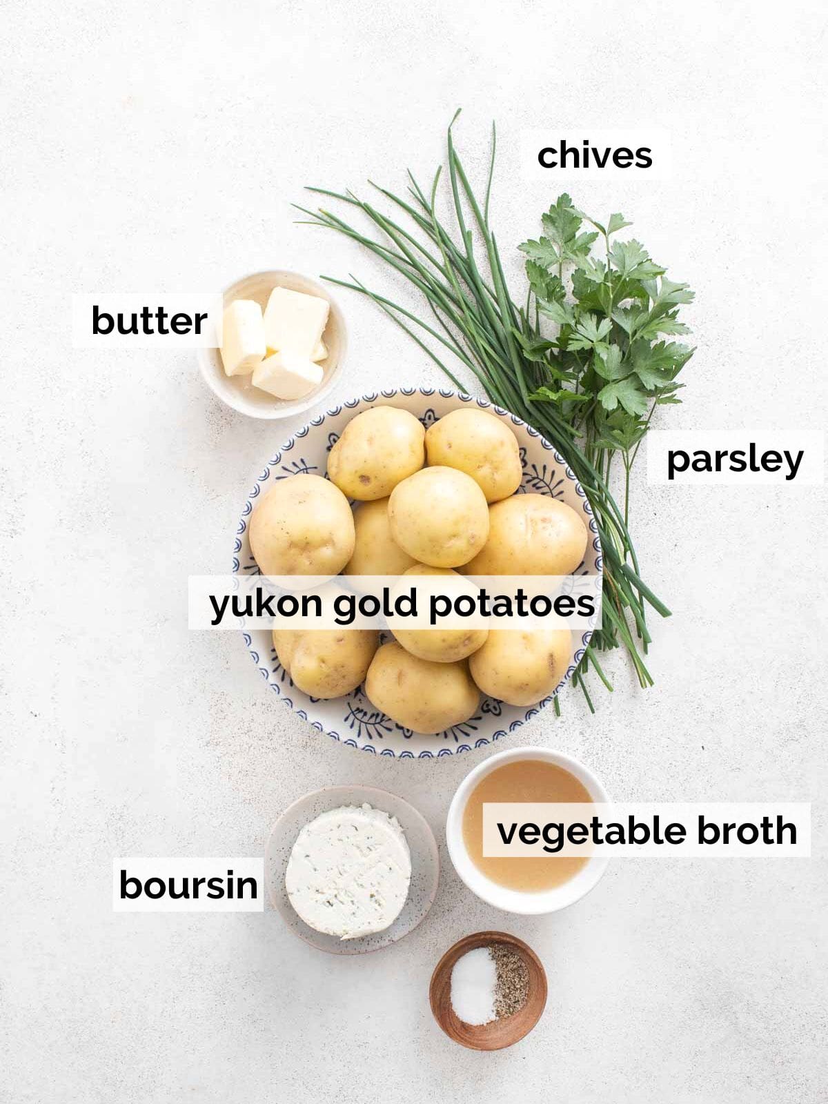 Potatoes, herbs, and boursin cheese with vegetable broth on a white background.