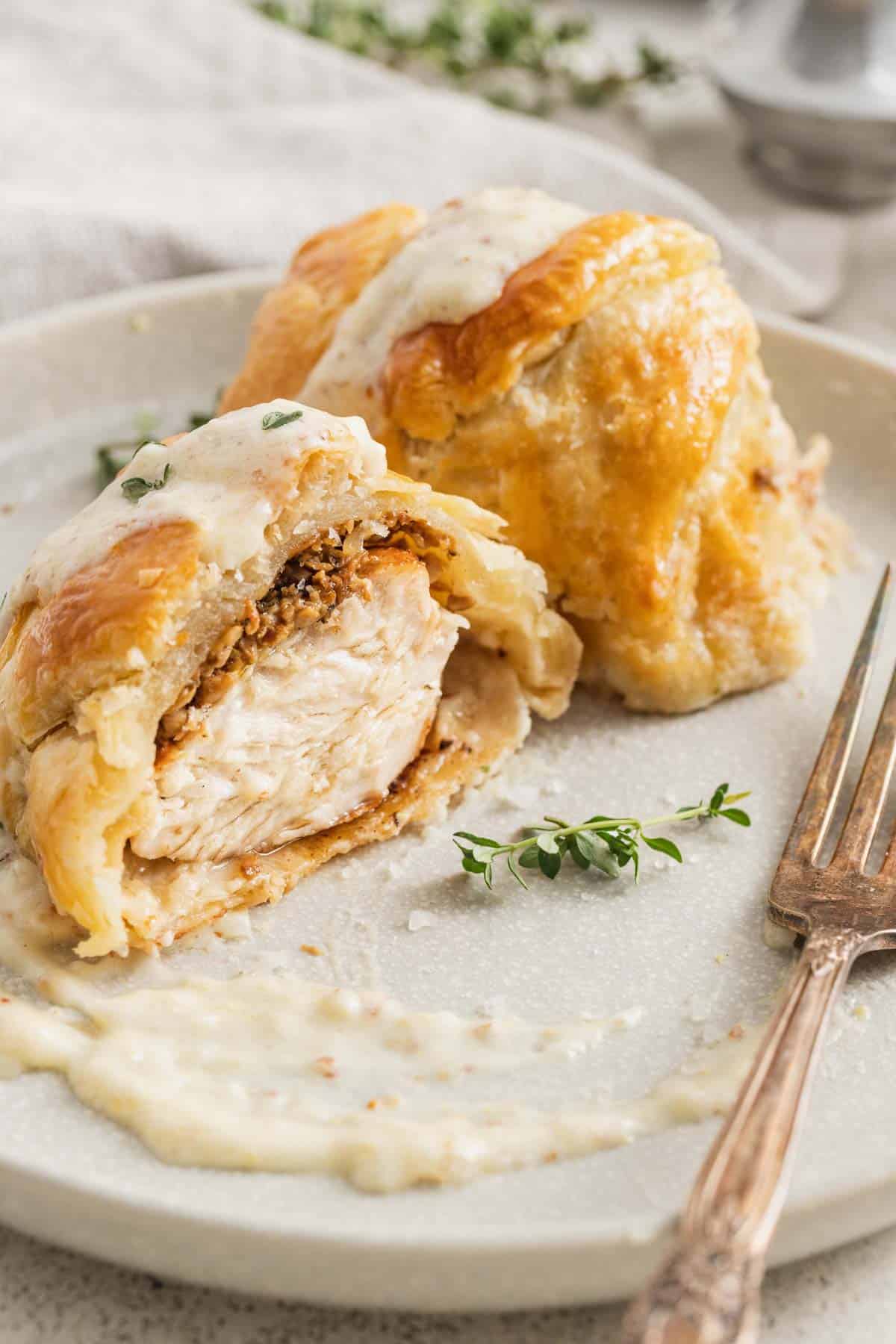 A chicken wellington cut in half and drizzled with dijon cream sauce. 