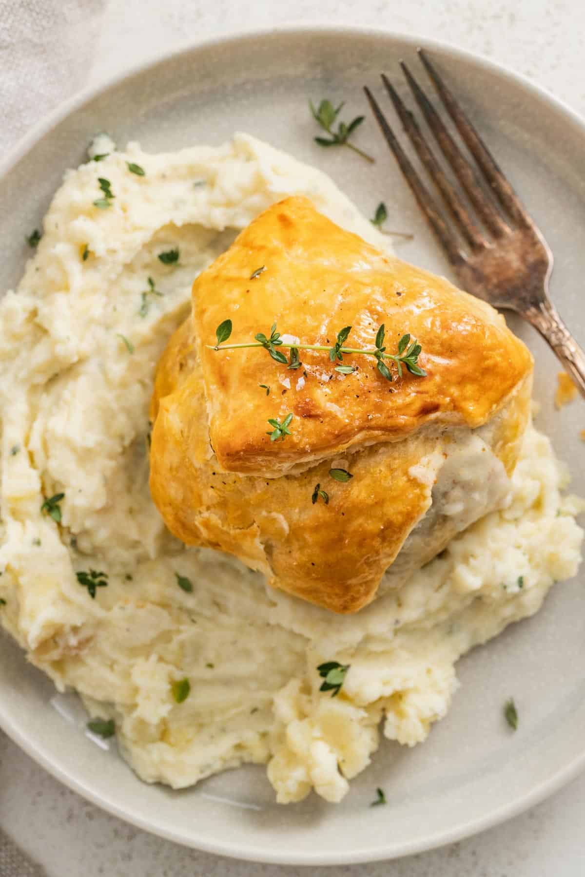 A chicken wellington placed on top of creamy Boursin mashed potatoes.