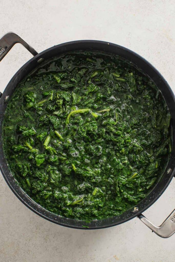 Boiling frozen spinach in hot water. 