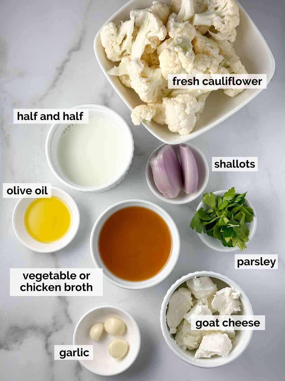Ingredients for cauliflower in a goat cheese sauce on a marble background.