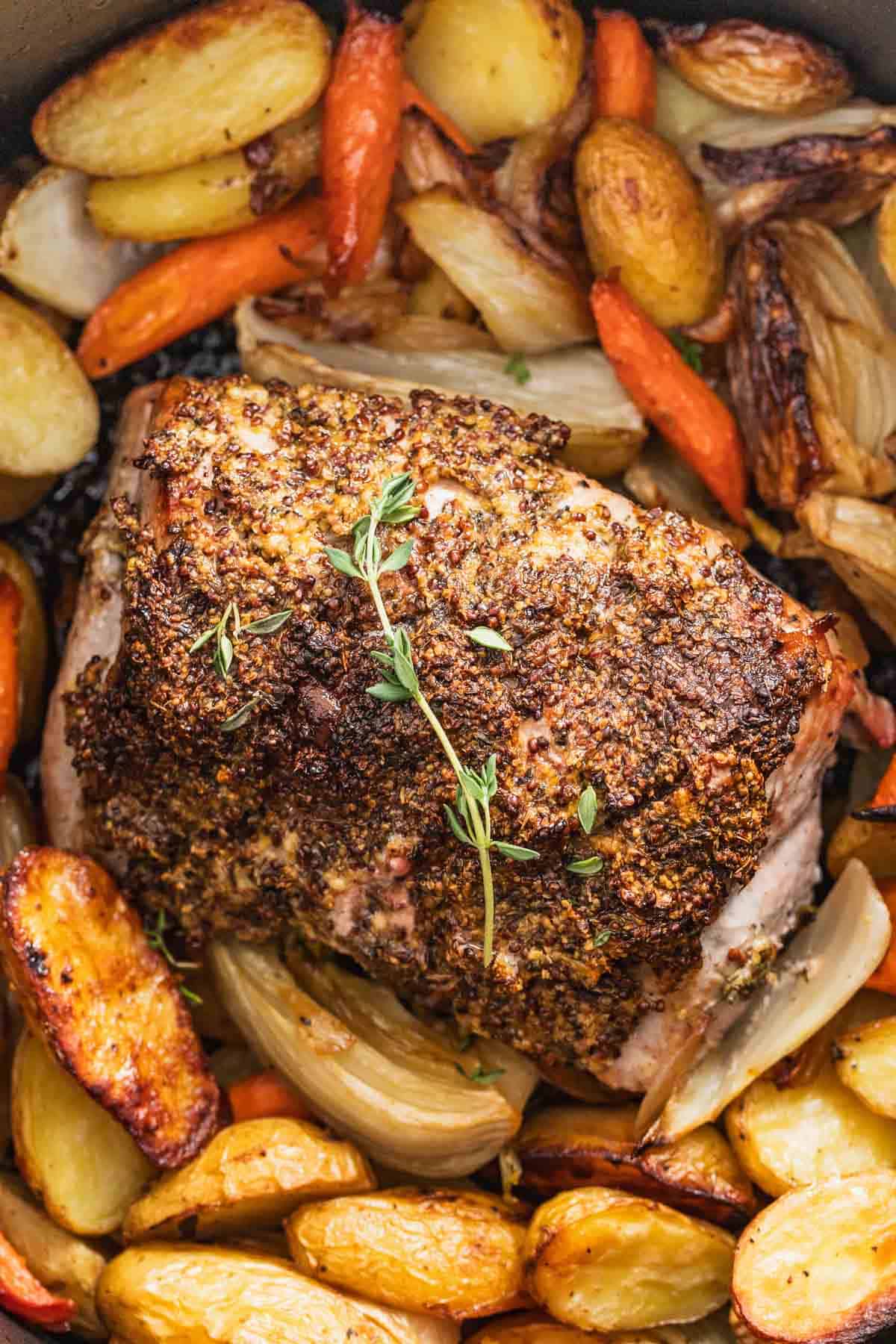 A pork roast topped with a dijon herb crust and thyme.