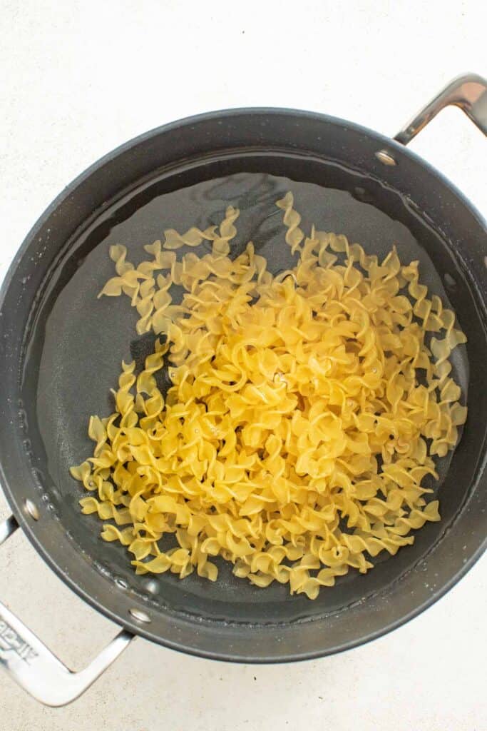 Egg noodles in a pot with water.