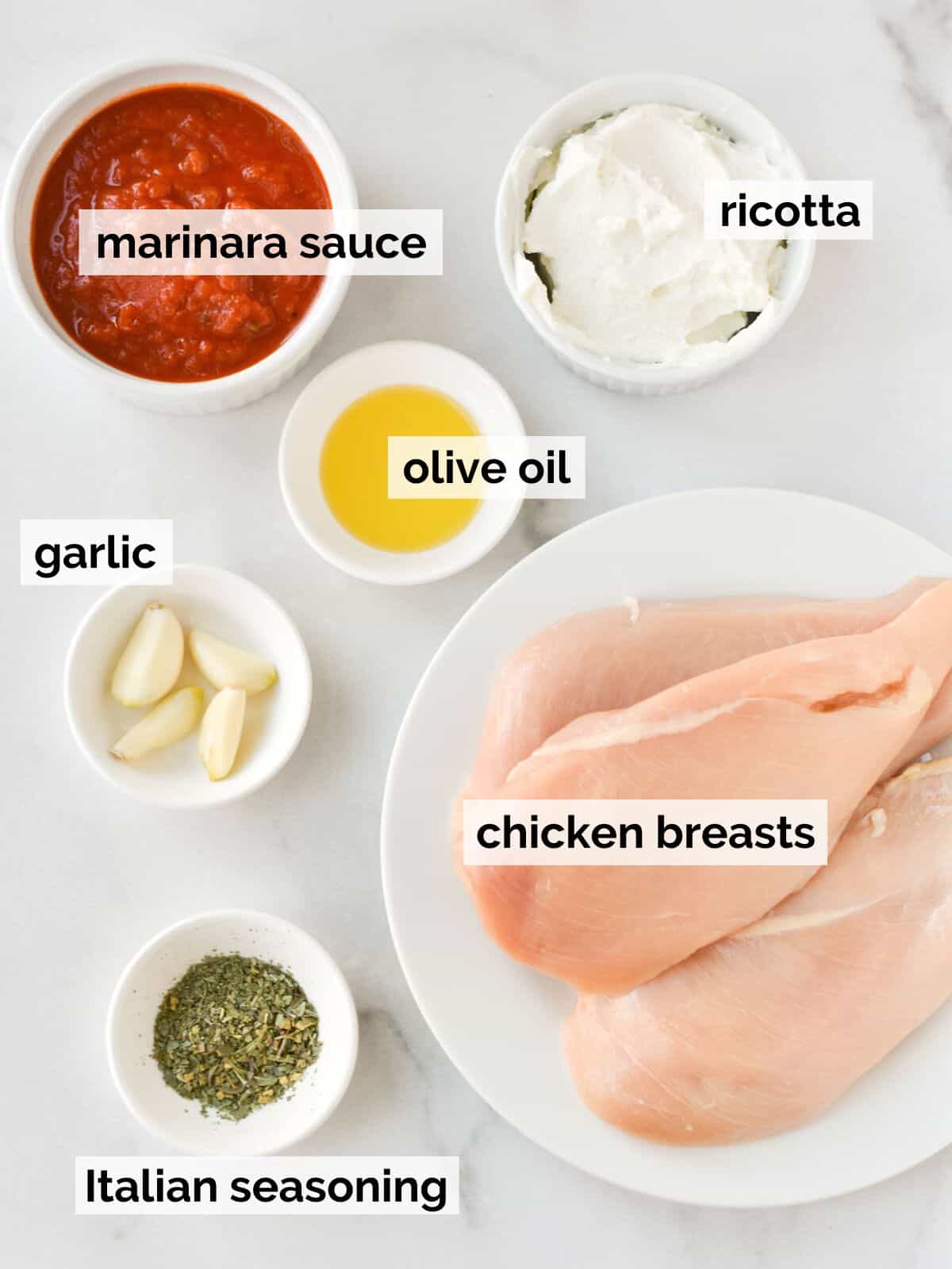 Ingredients for ricotta chicken on a white background.