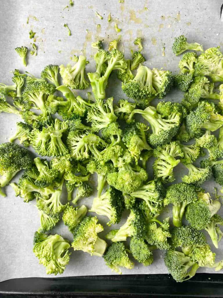 Chopped broccoli florets on a sheet pan.