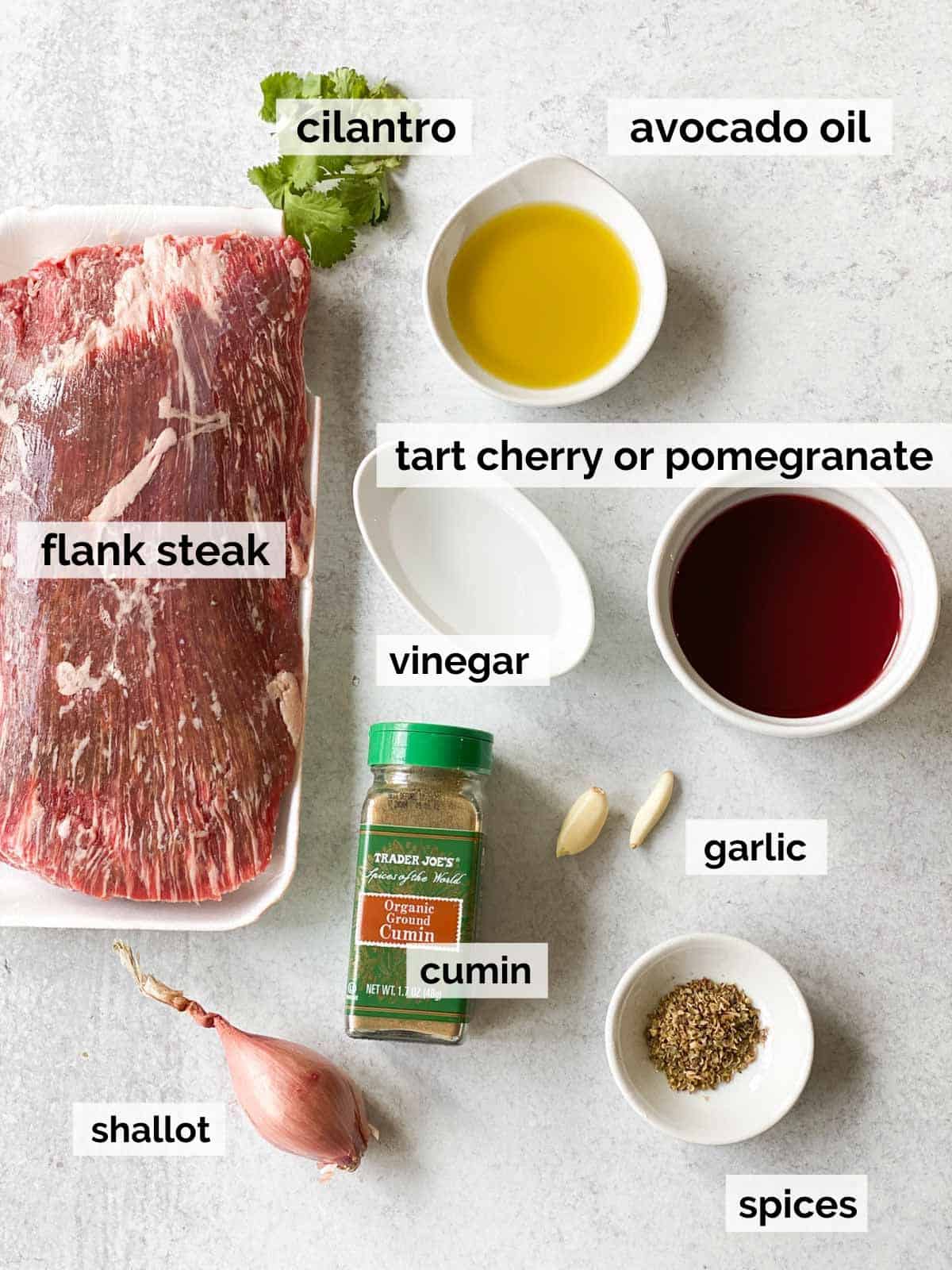 Ingredients for flank steak tacos on a white background.