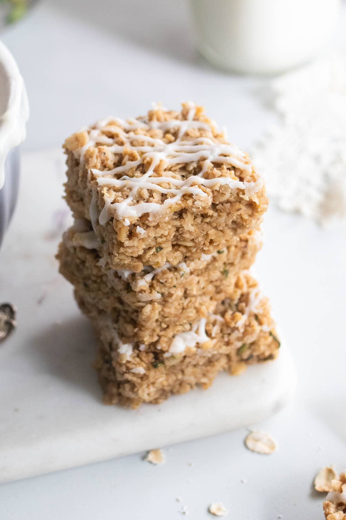 Stacked zucchini bars drizzled with cream cheese frosting. 