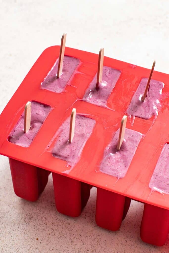 A popsicle mold filled with berry protein mix.