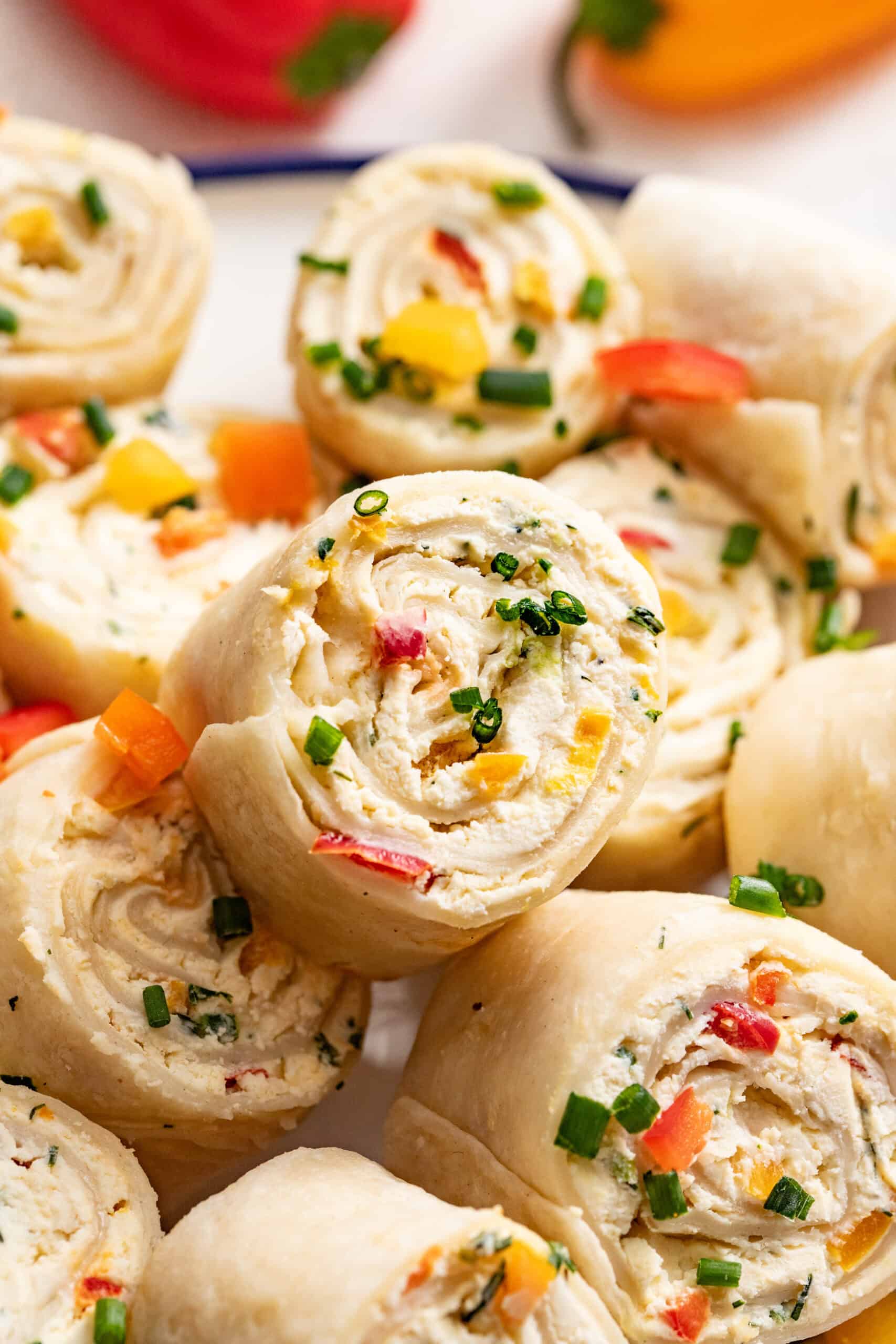 A close up shot of peppers and cream cheese rolled into a tortilla pinwheel.