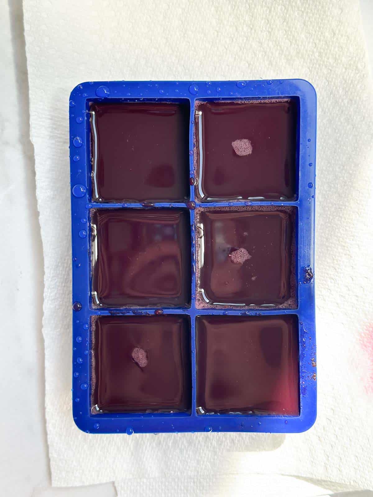 Blueberry ginger juice being frozen into ice cubes.