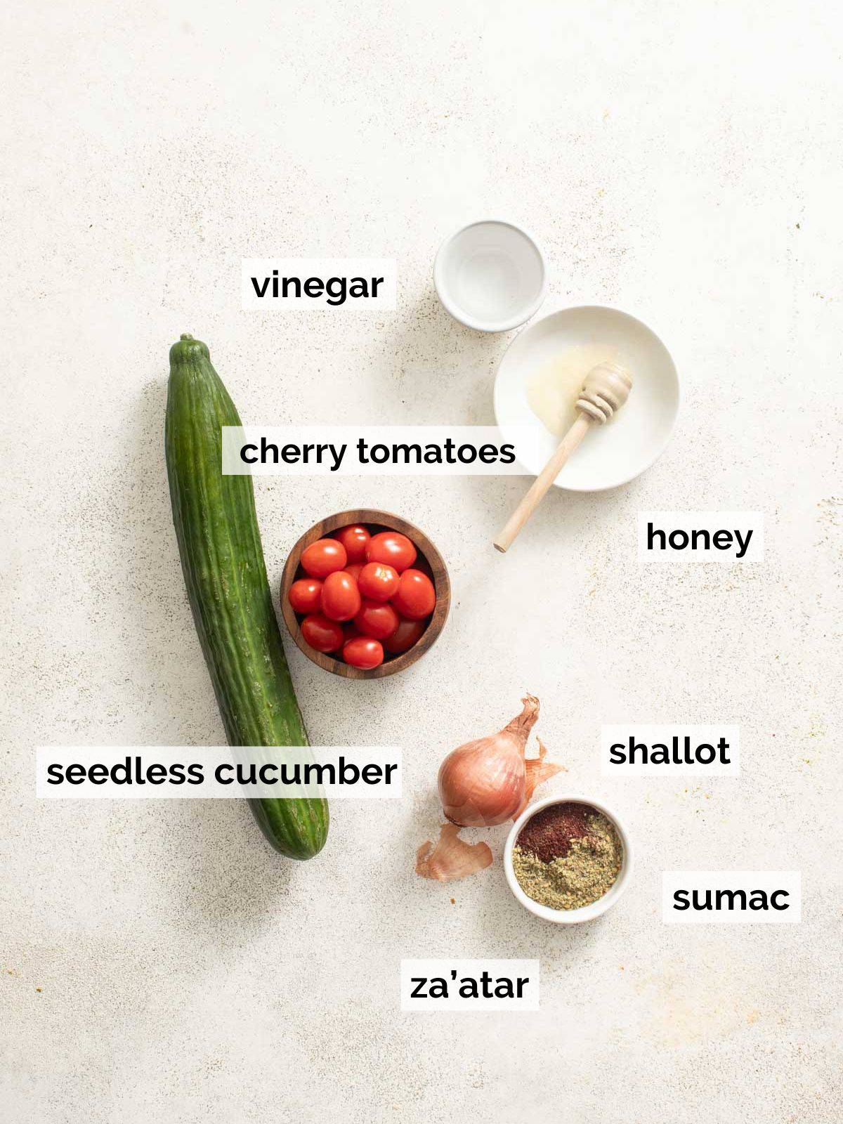 Ingredients for mediterranean cucumber salad on a white background.