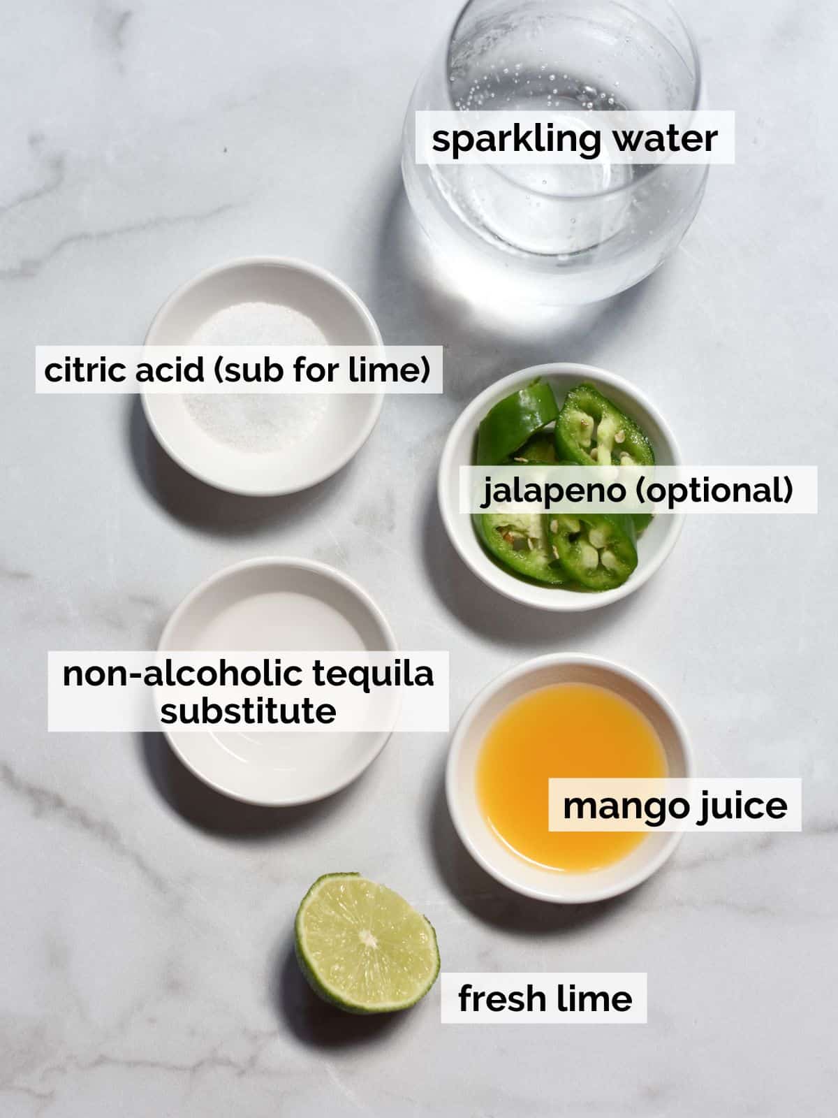 Ingredients for non-alcoholic margaritas on a white marble background.