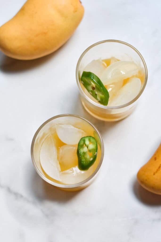 Filling a glass with ice, mango and lime juice.